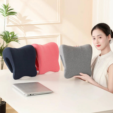 Woman holding gray Comfort Enhancing Desk Headrest Pillow For Office Use Ergonomic Memory Foam Chair Neck Support Breathable Head Cushion for desk naps next to black and pink versions on a desk.