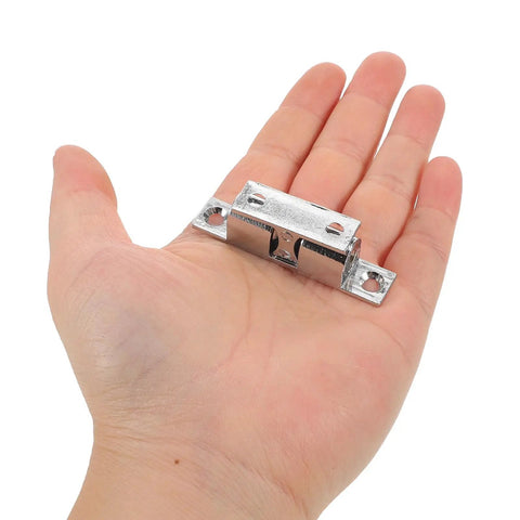 Person holding stainless steel boat door latch from four pack for RVs and closets, marine cabinet hardware, tough silver tension roller catches for secure doors