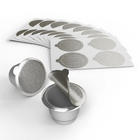 Aluminum Lids For Reusable Nespresso Original Line Capsules 200 Pack, metal lids and adhesive foil seals displayed with pods.