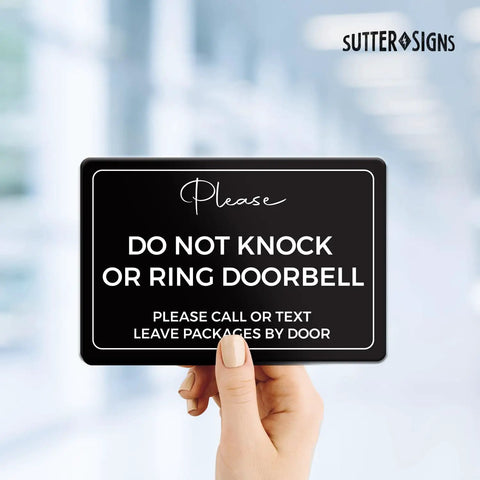 Hand holding the Do Not Knock Door Sign 4 By 6 Inch Durable ABS Plastic For Front Door And Home Office Do Not Ring Sign