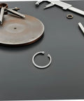 Five Piece Stainless Steel C Clips Kit For Grooved Shafts Heavy Duty Retaining Snap Rings Set With Multiple Sizes For Everyday Pro Grade Use And Quick Secure Fit on a workbench with tools.