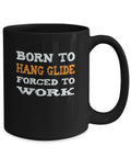 Black ceramic mug with "Born To Hang Glide Forced To Work" quote. Hang Gliding Mug For Adventure Junkies A Dope Ceramic Coffee Cup.