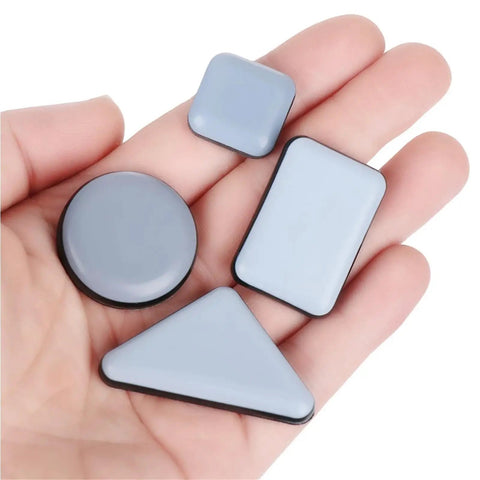 Heavy Duty Furniture Sliders Self Adhesive Floor Protectors Move Heavy Gear Without Breaking A Sweat 100 Pack in hand, various shapes, gray, smooth surface.