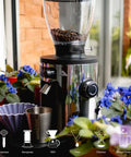 Barista Level Electric Coffee Grinder With Stepless Control And 54Mm Steel Flat Burrs Delivers Hella Consistent Grounds for Quick Home Brewing in a garden setting.