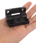 Black plastic 90 Degree Torque Friction Positioning Folding Cabinet Hinge shown on a human hand for scale.