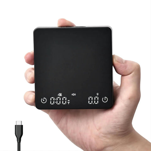 Hand holding black Palmsized Coffee Scale With Timer For Espresso And Pour Over, Rechargeable USB C, 2Kg Capacity, 0.1G Precision
