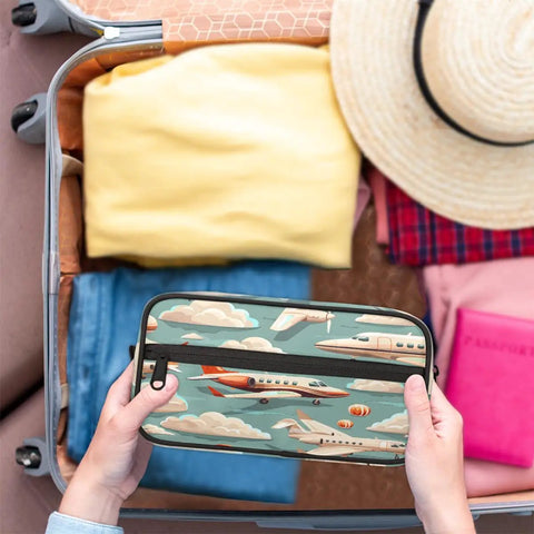 Person packing Air Travel Ready Cosmetic Bag For Women, Waterproof Makeup Organizer Pouch with airplane design into carry-on suitcase.