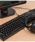 Top Shelf Mechanical Gaming Keyboard With Hella Responsive Switches Backlit Full Size Wired Usb Layout Splash Proof Build And Ultra Slim Matte Finish For Snappy Typing Days on desk beside gaming headset.