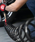 Person using Lightweight Polyurethane Recoil Air Hose Three Eighth Inch Lite Five Sixteen Inch Fifty Feet With One Quarter Inch MNPT Quick Coupler Connector Brass I M Style Plug Heavy Duty All Weather Bend Restrictors For Home Garage And Workshop on car tire