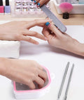 Two Pack Nail Soak Off Bowl Kit For Gel Polish Remover And Dip Powder, Includes 2 Bowls, Triangle Cuticle Peeler, Stainless Steel Cuticle Pusher, Pro Grade Nail Art Tools, Pink shown in use during a manicure session.