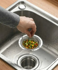 Ditch the Plumbing Headache Forever with This Tough Stainless Steel Sink Strainer Mesh Drain Catcher Filter Screen Traps Hair Food Crumbs and Bathtub Gunk while Keeping Things Moving Smooth; hand holding strainer with chopped vegetables over sink.