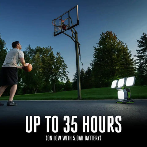 Outdoor evening scene with Rechargeable Portable Work Light Up To 10,000 Lumens With 360-Degree Folding Panels illuminating a basketball hoop.