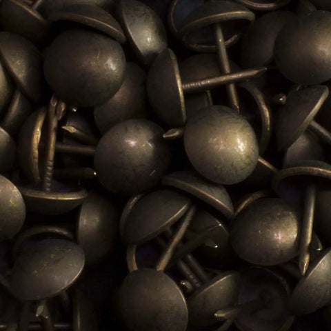 Close-up of 100 Pack Dark Antique Brass Upholstery Tacks For Chairs And Headboards, arranged with visible 1/2 inch shank.