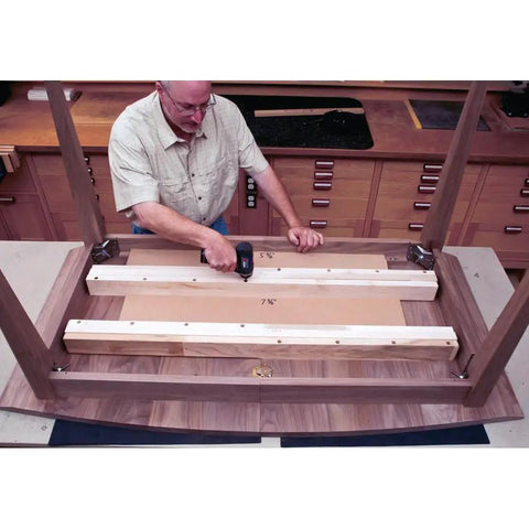 Man installing Heavy Duty Twenty Eight Inch Wood Table Extension Slides Packing Slick Rack And Pinion Action under a wooden table.