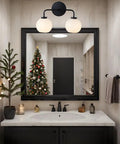 Double Glass Globe Wall Sconce, 17 Inch Sleek Modern Design In Matte Black above bathroom mirror with Christmas decor