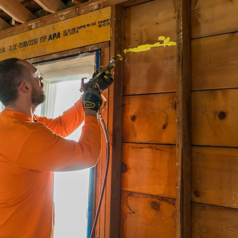 Professional Grade Interior Air Sealant Kicks Drafts To The Curb And Locks Warmth In Along Wall Ceiling Floor Joints Yellow 5 Gallon Big Bucket applied by a worker.