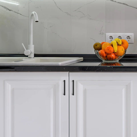 Modern kitchen with sink and fruit bowl, featuring matte black 30 Pack 5 Inch Kitchen Square Cabinet Handles on white cupboard doors.