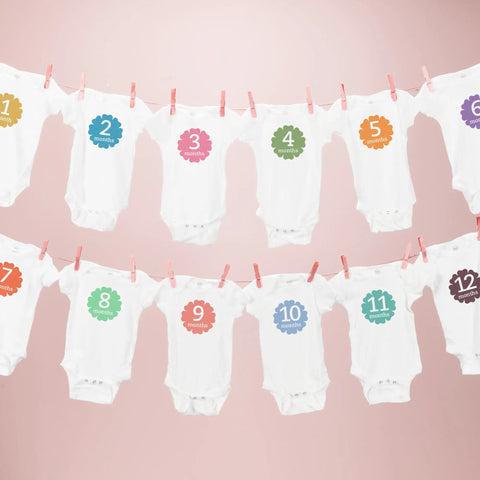 Baby onesies with month numbers hanging on a line, illustrating transfer potential of Stretchable Heat Transfer Paper For Light Fabrics Inkjet Printer Ready 8.5 X 11 Inch Sheets 5 Count Easy Iron On Transfers That Stretch With Your Fabric Soft Feel Ideal For Custom Tees.