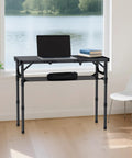 Tri Fold Aluminum Camping Table With Storage Net and Adjustable Heights, set up as a desk near a window with a lake view.