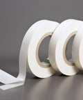 Three rolls of Double Coated Kraft Paper Tape 2 Inch By 36 Yard White With Beefy Grip Adhesion for holding, mounting, and splicing.