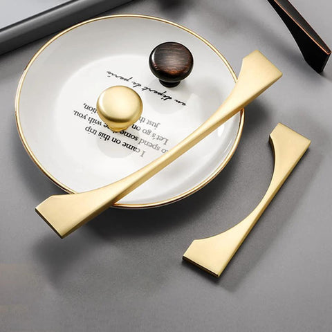 4 Pack Brushed Gold Cabinet Drawer Pulls in Zinc Alloy with Brushed Brass Finish, shown on a gray surface with circular decor.