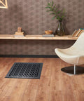 Room scene with Decorative Cast Aluminum Floor Register 10 By 12 Tudor Mushroom Design With Adjustable Dampers Black Finish on wooden floor.