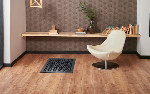 Room scene with Decorative Cast Aluminum Floor Register 10 By 12 Tudor Mushroom Design With Adjustable Dampers Black Finish on wooden floor.