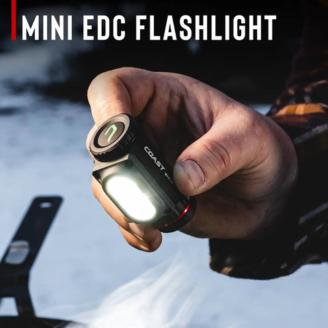 Person holding mini EDC flashlight outdoors