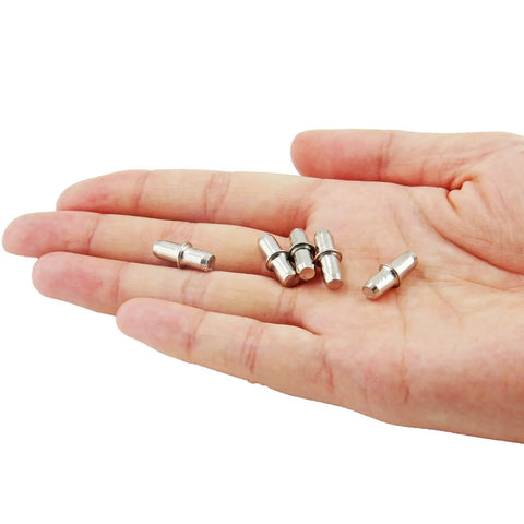 Slick Nickel Plated Iron Shelf Pins For Kitchen Cabinets And 50 Pack Of 5mm Heavy Duty Drawer Supports shown in hand.