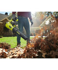 A person using a Brushless Cordless Leaf Blower Packs Serious Gas Powered Punch At 125 Mph And 550 Cfm for yard cleanup.