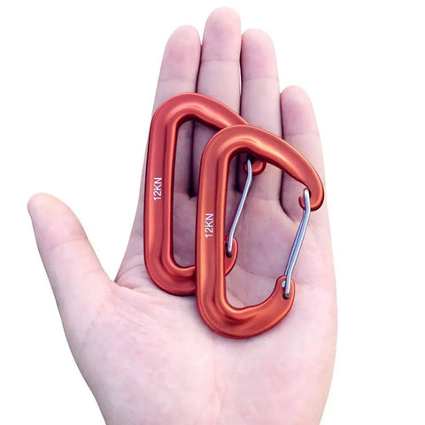 Hand holding two orange Dope Lightweight 12KN Aluminum Carabiner Clip Wiregate Heavy Duty For Hammocks Camping Key Chains Outdoor Gym Hiking