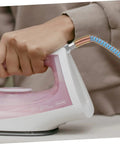 Close-up of hand holding a steam iron connected to High Temperature Steam Hose for Steam Irons, heavy duty flexible tube