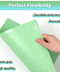 Side view of two green HTVRONT 12x12 cutting mats with white grid lines and edge rulers for Cricut machines.