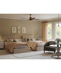 Chic bedroom with twin beds, modern neutral decor, round coffee table, and a window draped with soft beige curtains.