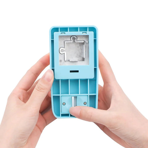 Hands holding a 1 Inch Puzzle Hole Puncher For DIY Jigsaw Crafts Portable Cardboard Cutter with jigsaw piece opening.