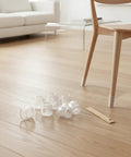 Clear Trim To Fit Furniture Leg Protectors With Adjustable Glides PVC Floor Pads For Hardwood Tile And Laminate Floors shown on chair legs.