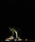Person using Double Power Rechargeable CREE LED Headlamp with 1800 Lumens at night, showing its powerful illumination.