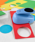 Blue XL 3 Inch Circle Punch for Paper Crafts and Scrapbooking with spring action lever shown cutting colored cardstock circles