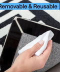 Hand removing sticker from corner of rug showing Rug Gripper Pad Kit With 24 Reusable Double Sided Stickers Keeps Rugs Flat