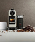 Slick Compact Coffee And Espresso Machine With Integrated Milk Frother Glossy White, coffee mug, coffee beans on counter.