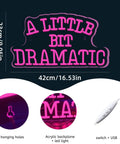 A Little Bit Dramatic neon sign with pink LED glow, acrylic backplate, USB switch, 42x23cm size showing hanging holes.
