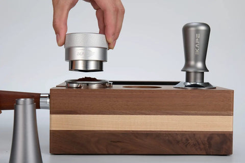 Hand using 53mm Gravity Adaptive Espresso Distributor for 54mm Portafilters, Fits Breville Bottomless Portafilter, 304 Stainless Steel Coffee Tool