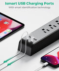 Close-up of a 12Foot Power Strip Surge Protector with 6 outlets and 4 USB ports charging devices, emphasizing USB charging feature.