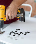 Person using a drill to install Rock Solid Heavy Duty 30 Piece Invisible Cabinet Connector Set featuring iron fasteners.