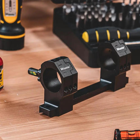 One Piece Bolt Action Scope Mount With Thirty Mil Medium Rings For Remington Seven Hundred Short Action on a workbench.