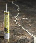 Pro Grade Polyurethane Sealant For Concrete Brick And Stone Heavy Duty Horizontal Formula applied to crack in dark concrete surface.