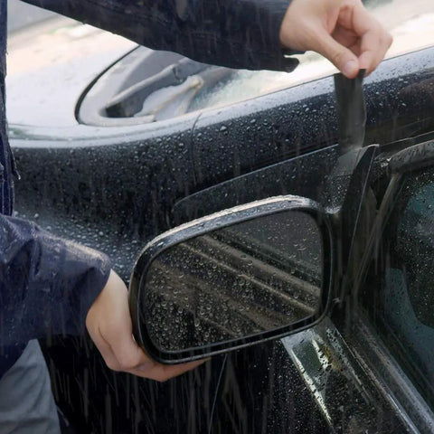 Applying Mini Black Rubberized Waterproof Tape For Quick Seals And Patches on a wet car mirror for a watertight seal.