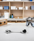 Rock Solid Mini Ratchet Wrench With 1/4 Inch Double Ended Reversible Socket and Knurled Finger Grip on a workspace.