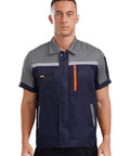 Men's Heavy Duty Mechanic Work Shirt Built Tough For The Daily Grind With Reflective Safety Stripes And Durable Zippered Front Short Sleeve Shop Uniform Jacket In Gray And Navy Blue, model wearing front view.