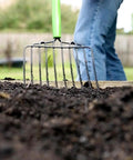 61 Inch Heavy Duty 10 Tine Welded Steel Bedding Fork Workhorse with hardwood handle in use, moving soil in garden close-up view.